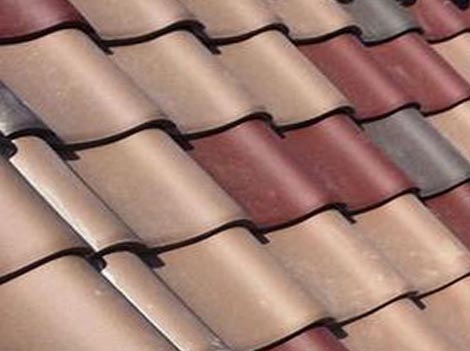 Construction roofing crew uses power tools to screw and fasten sheet metal to the roof rafters of a building.